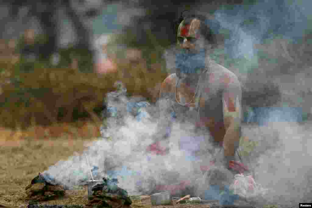 Smoke rises as a Hindu holy man, or sadhu, performs religious rituals at the premises of Pashupatinath Temple during the Shivaratri festival in Kathmandu, Nepal.