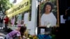 FILE - A woman places flowers on an altar set up in honor of Berta Caceres during a demonstration outside Honduras' embassy in Mexico City, June 15, 2016.