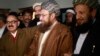 Maulana Sami ul-Haq (front C), one of the Taliban negotiators, and Irfan Siddiqui (front L), a government negotiator, shake hands after a news conference in Islamabad on February 6, 2014. 