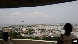Visitors look out over U.S. Marine Corps Air Station Futenma in Ginowan on Okinawa, Japan, May 3, 2010. The Japanese and U.S. governments want the Futenma Air Base located in the middle of a crowded city moved to a sparsely populated area for safety reaso
